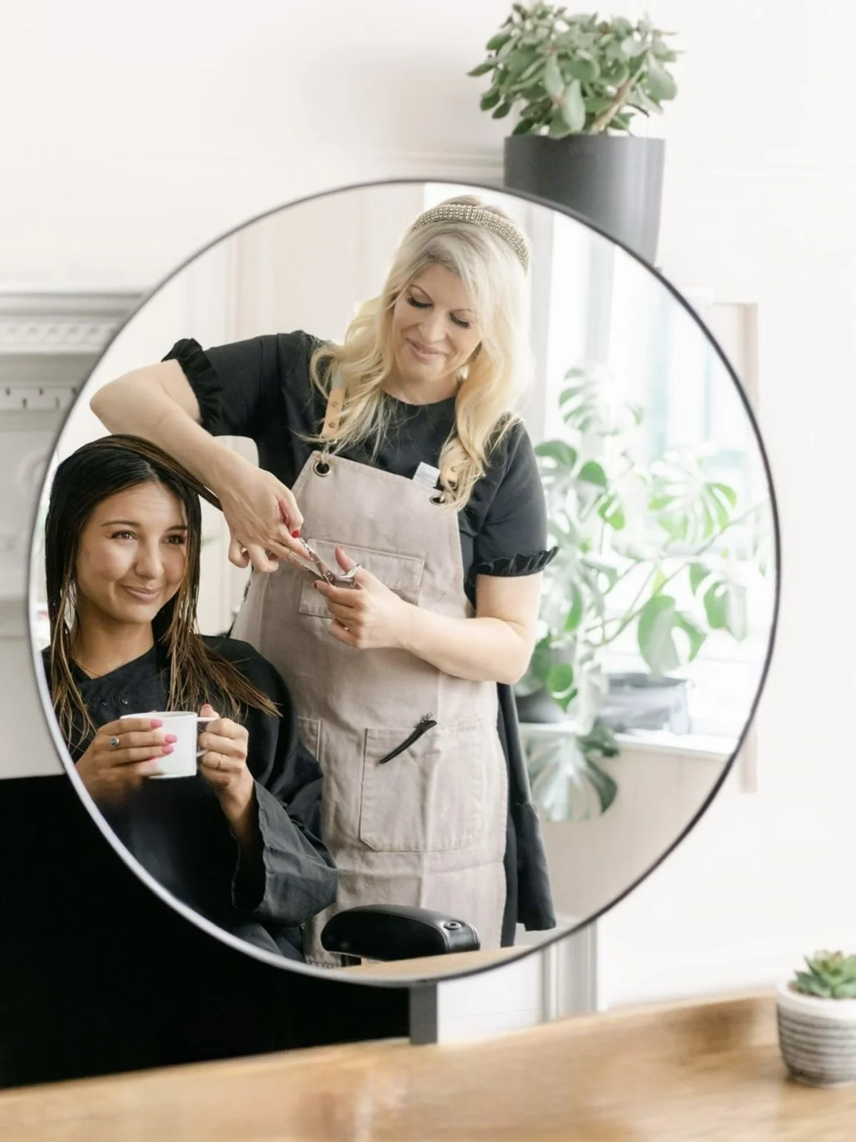 Sanchia working with a client in the salon mirror